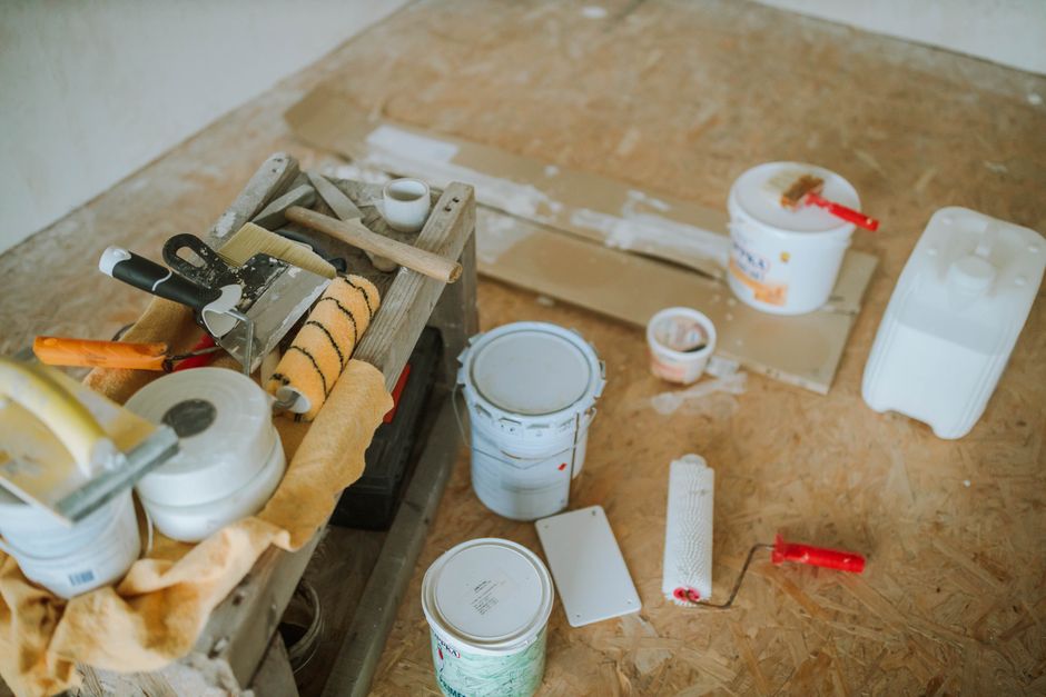 Een professional voert herstelwerkzaamheden uit aan een houten vloer in een woning.